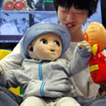 Image of a woman interacting a robot baby